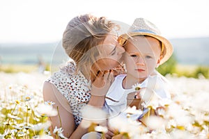 Mother and son are playing in a green meadow.