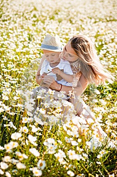 Mother and son are playing in a green meadow.