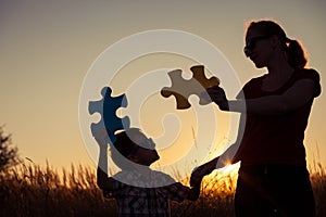 Mother and son playing at the park at the sunset time