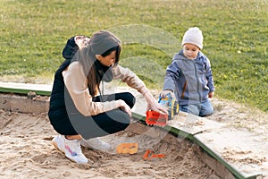 Mother and son playing in sandbox. Little builder. Education, and imagination, purposefulness concept. Support childhood