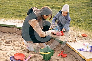 Mother and son playing in sandbox. Little builder. Education, and imagination, purposefulness concept. Support childhood