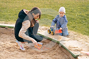 Mother and son playing in sandbox. Little builder. Education, and imagination, purposefulness concept. Support childhood