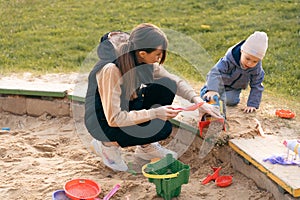 Mother and son playing in sandbox. Little builder. Education, and imagination, purposefulness concept. Support childhood