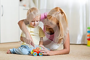 Mother and son playing with toy cars indoors