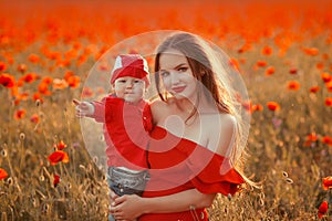 Mother with son in poppies enjoying life at sunset. Happy family