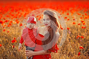 Mother with son in poppies enjoying life at sunset. Happy family