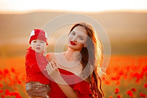 Mother with son in poppies enjoying life at sunset. Happy family