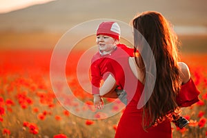 Mother with son in poppies enjoying life at sunset. Happy family