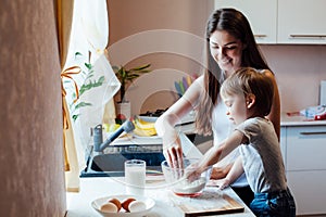 Mother and son prepare pie with flour