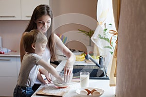 Mother and son prepare pie with flour