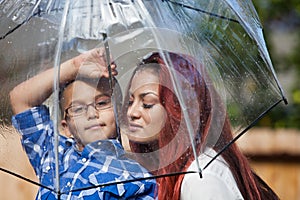 Mother and son in the rain with umbrella