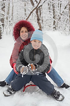 Mother, son ride on sled