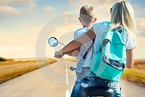 Mother and son rides on motorbike.