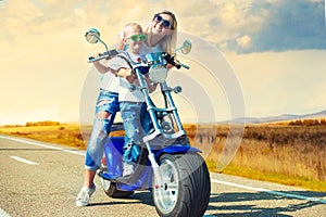 Mother and son rides on motorbike.