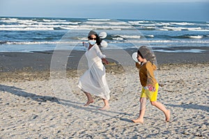 Mother and son running beach during Coronavirus