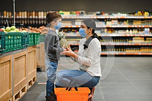 Mother and son are shopping at the grocery store. They wear masks during quarantine. Coronavirus Pandemic .COVED-19