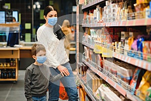 Mother and son are shopping at the grocery store. They wear masks during quarantine. Coronavirus Pandemic .COVED-19