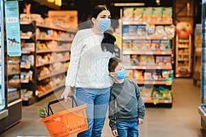 Mother and son are shopping at the grocery store. They wear masks during quarantine. Coronavirus Pandemic .COVED-19