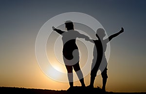 Mother and son silhouetted by the setting sun