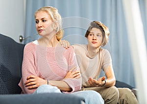 Mother and son sitting after quarrel at home