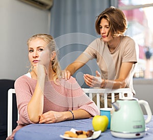 Mother and son sitting after quarrel at home