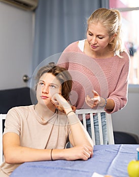 Mother and son sitting after quarrel at home