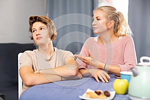 Mother and son sitting after quarrel at home