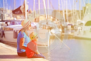 Mother and son sitting in summer port