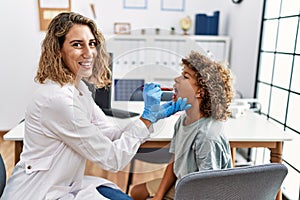 Mother and son smiling confident examining thoat at clinic