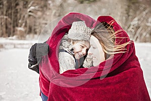 Mother and son snuggling under blanket