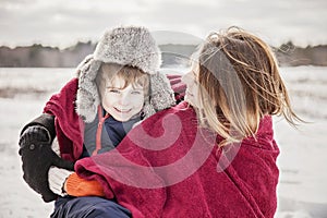 Mother and son snuggling under blanket