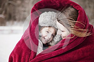 Mother and son snuggling under blanket