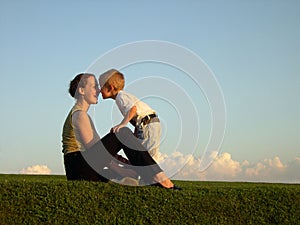 Mother with son on sundown kiss by nose photo