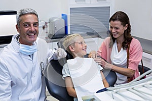 Mother and son talking while dentist examining