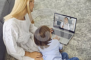 Mother with son talking to doctor online from home. Parent and little boy having video call with pediatrician on laptop