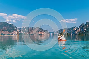 Mother with son together floating on kayak by the Cheow Lan lake in exotic Thailand. Traveling with kids concept image