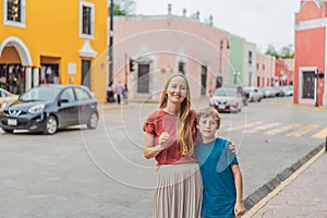 Mother and son tourists explore the vibrant streets of Valladolid, Mexico, immersing herself in the rich culture and photo