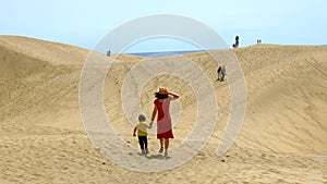 Mother and son tourists exploring the dunes of Maspalomas, Gran Canaria