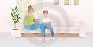 Mother with son using laptops happy family spending time together modern living room interior