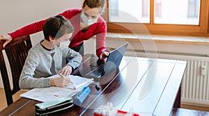 Mother and son in video chat with teacher wearing masks