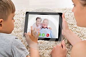 Mother And Son Videoconferencing On Digital Tablet