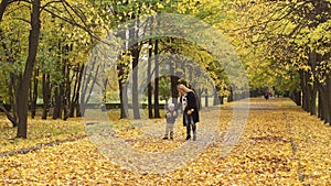 Mother and son walking in autumn Park.