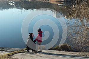 Mother with son walking near lake