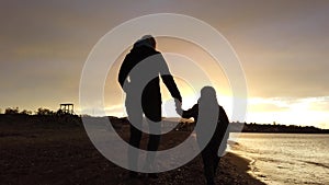 Mother and son walking on Tsilivi beach at dusk