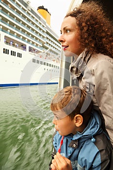 Mother and son watch on cruiser from boat