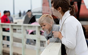 Mother and son watching wildlife from a pier