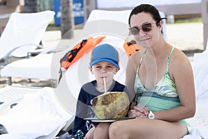 Mother with Son Wearing Good Sun Protection Clothes Sit on a Chair at Punta Mita, Nayarit, Mexico, on the Beach while the Boy