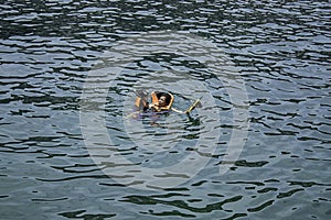 Mother and son wearing a life jacket, scuba diving in the sea