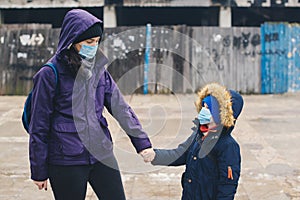 Mother and son wearing a protective mask on the street. Stop the infection. Health care concept. Mask against infectious diseases