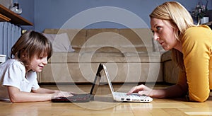 Mother and son working on two small laptops